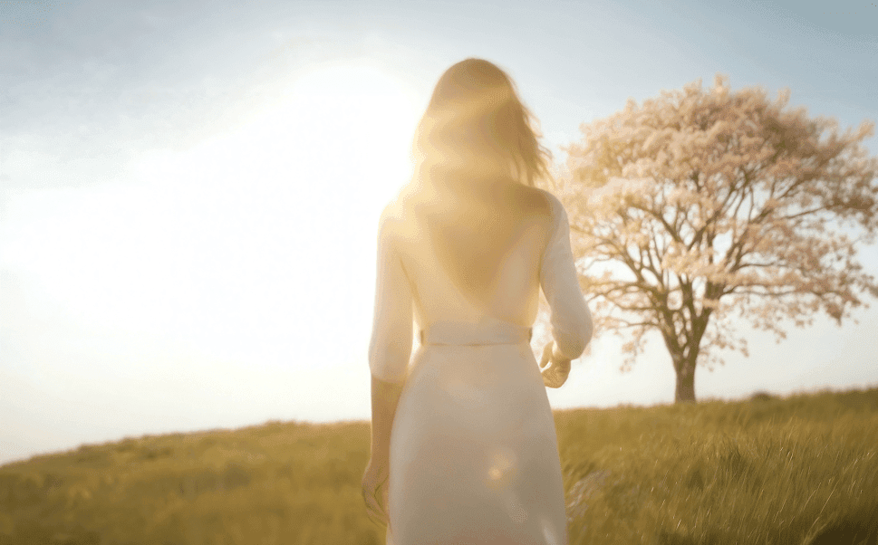Woman walking toward a cherry blossom tree